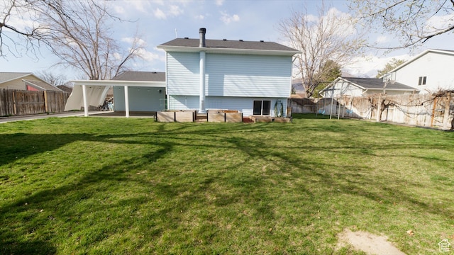 rear view of house featuring a yard, a fenced backyard, a patio, and a carport