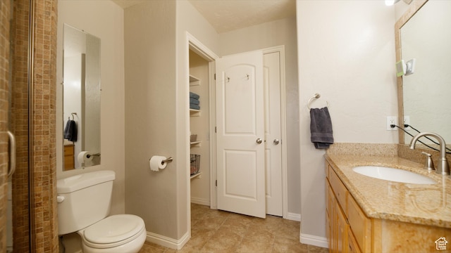 full bathroom with vanity, baseboards, and toilet