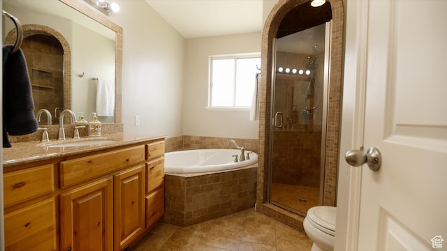 bathroom with a garden tub, a shower stall, vanity, toilet, and tile patterned floors