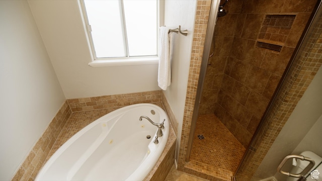 bathroom with a stall shower and a tub with jets