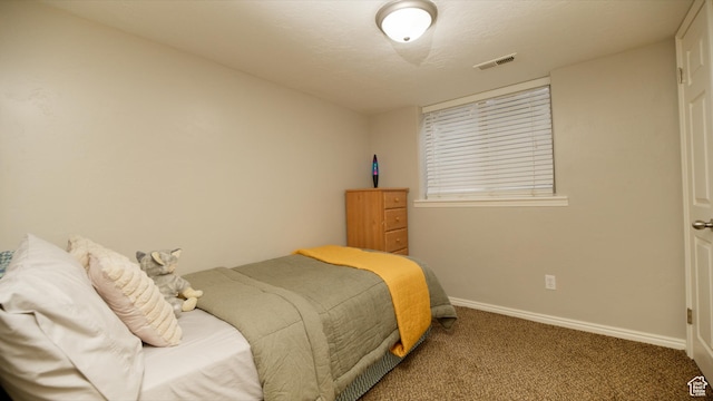 bedroom with carpet flooring, visible vents, baseboards, and a textured ceiling