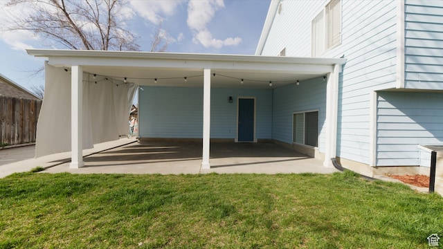rear view of house with fence and a lawn