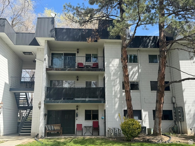 view of building exterior featuring cooling unit and stairway