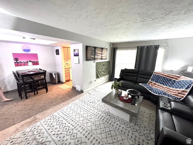 living area with baseboards, a textured wall, and a textured ceiling