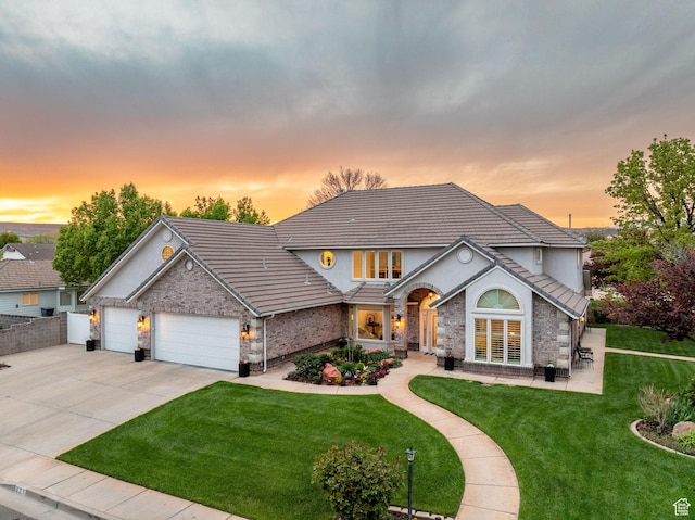 827 E 1070 S, St George, UT 84790 - traditional-style house with a front yard, a garage, a tile roof, concrete driveway, and brick siding