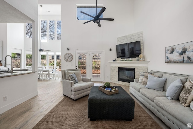 827 E 1070 S, St George, UT 84790 - living area featuring baseboards, a stone fireplace, ceiling fan, wood finished floors, and french doors
