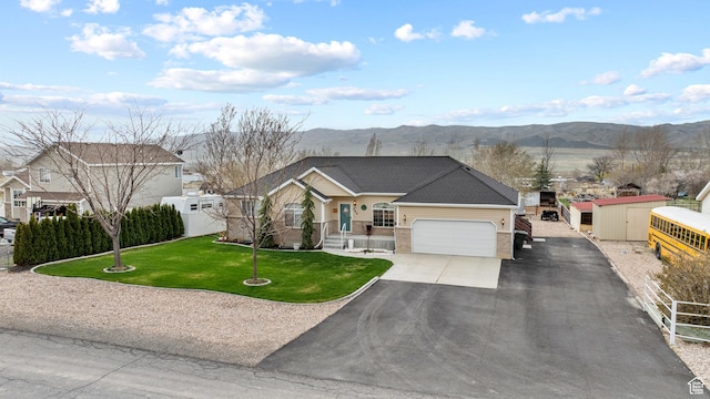 view of front of house featuring a front yard, a mountain view, a garage, aphalt driveway, and brick siding