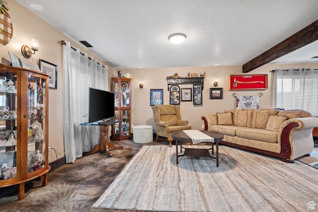 living room featuring beamed ceiling, baseboards, dark colored carpet, and a textured ceiling