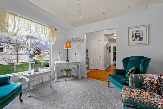 sitting room featuring carpet floors, baseboards, and vaulted ceiling