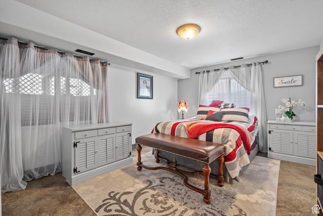 bedroom featuring visible vents, finished concrete flooring, and a textured ceiling