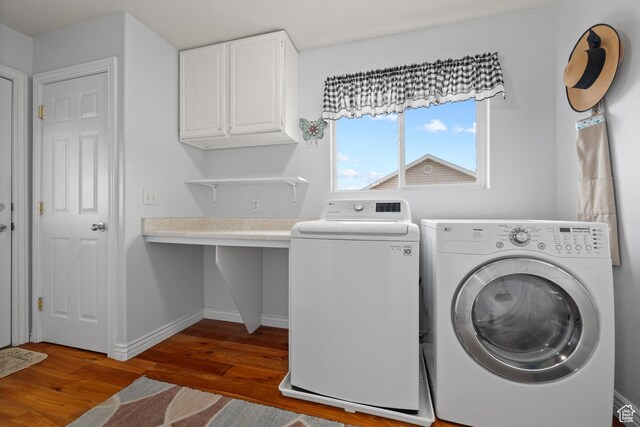 laundry area featuring washer and dryer, wood finished floors, baseboards, and cabinet space