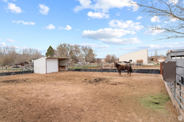 view of yard featuring an outbuilding, an exterior structure, and a rural view