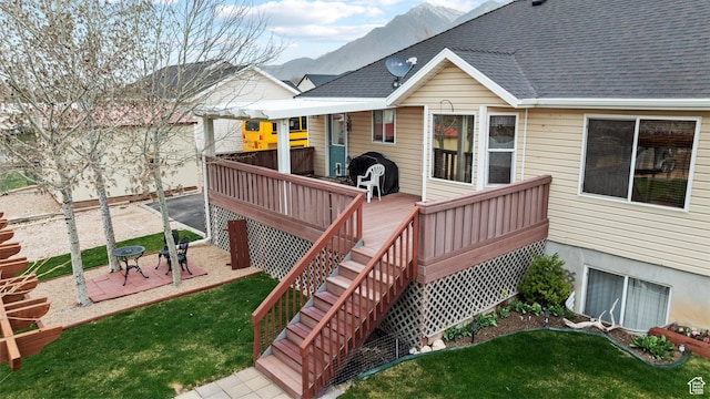deck with a yard, a mountain view, and a patio