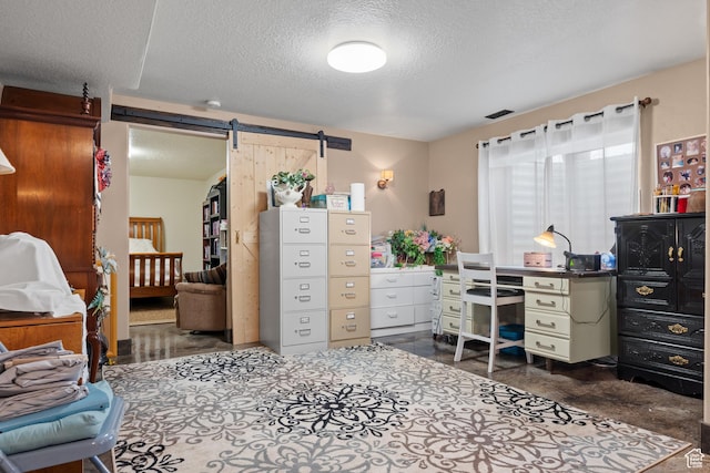 home office with a textured ceiling, visible vents, and a barn door