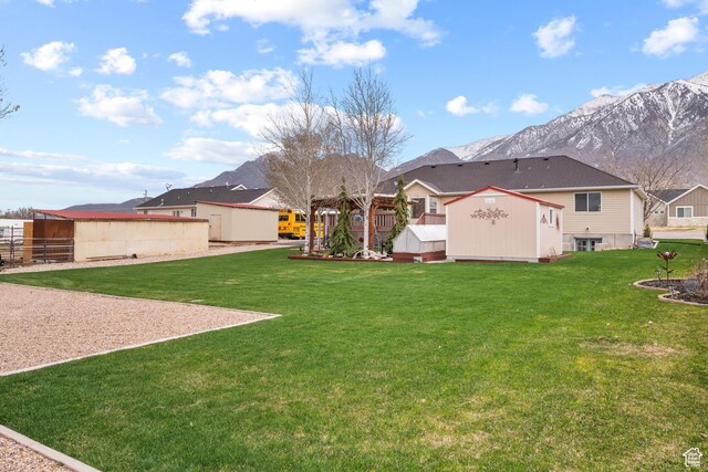 view of yard with a residential view, an outbuilding, a mountain view, and a shed