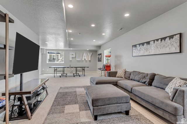 living area with light carpet, recessed lighting, a wealth of natural light, and a textured ceiling