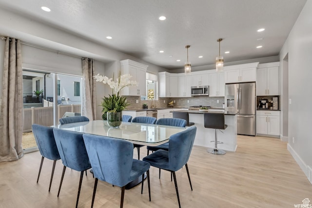 dining area featuring recessed lighting, light wood finished floors, and baseboards