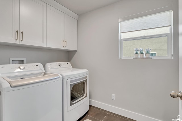 washroom featuring cabinet space, dark tile patterned floors, separate washer and dryer, and baseboards