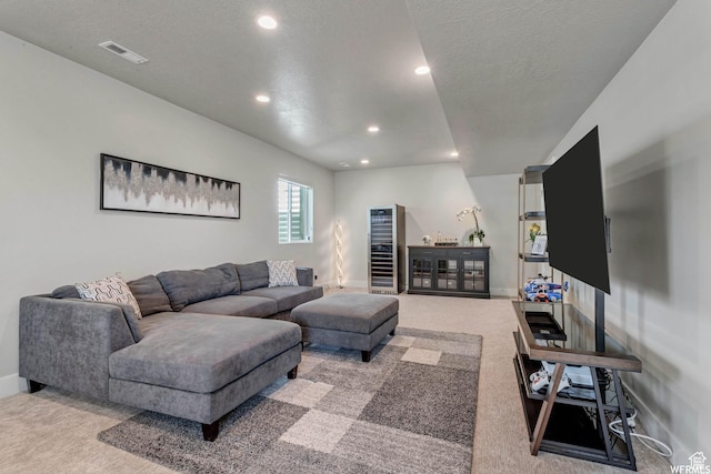 carpeted living area featuring visible vents, baseboards, recessed lighting, and a textured ceiling