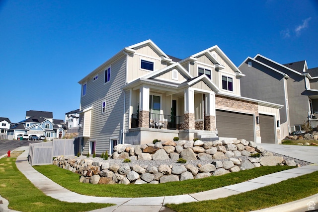 craftsman-style home with stone siding, a garage, board and batten siding, a residential view, and driveway