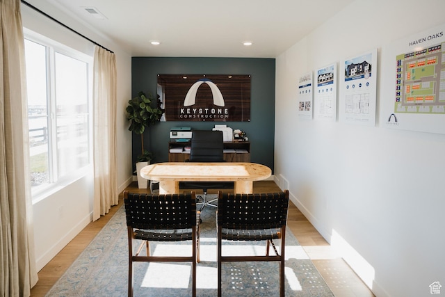dining space with light wood-type flooring, baseboards, and visible vents