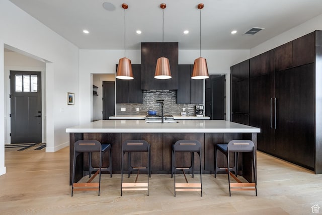 12709 N Belaview Way, Hideout, UT 84036 - kitchen featuring light wood-style floors, modern cabinets, visible vents, light countertops, and decorative backsplash