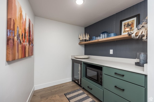 12709 N Belaview Way, Hideout, UT 84036 - kitchen with green cabinets, wood finished floors, stainless steel microwave, light countertops, and baseboards