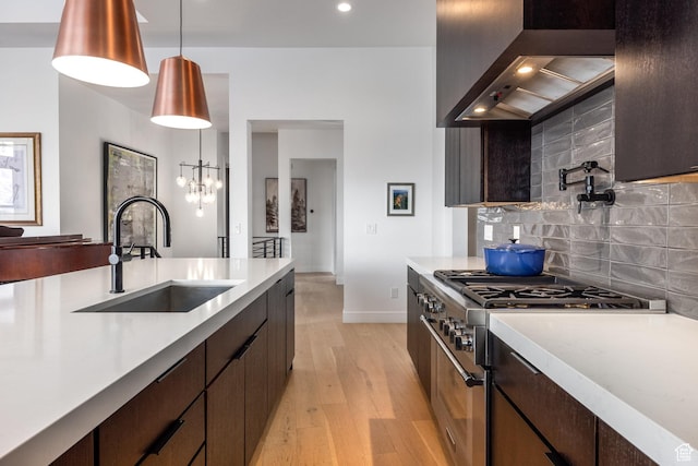 12709 N Belaview Way, Hideout, UT 84036 - kitchen featuring wall chimney range hood, light countertops, backsplash, double oven range, and a sink