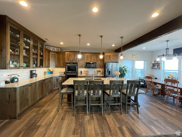 3525 S Sweetwater Pkwy, Garden City, UT 84028 - kitchen with stainless steel appliances, dark wood-type flooring, tasteful backsplash, a kitchen breakfast bar, and recessed lighting