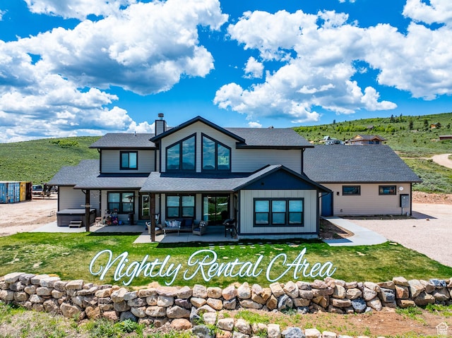 3525 S Sweetwater Pkwy, Garden City, UT 84028 - back of property featuring a hot tub, a patio, a yard, and a shingled roof