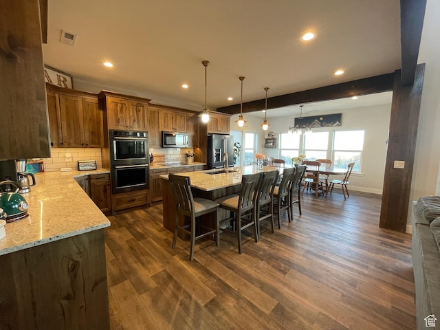 3525 S Sweetwater Pkwy, Garden City, UT 84028 - kitchen with stainless steel appliances, recessed lighting, decorative backsplash, a kitchen breakfast bar, and dark wood-style flooring