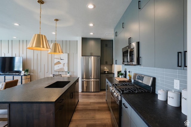 kitchen with dark countertops, backsplash, appliances with stainless steel finishes, and dark wood-style flooring