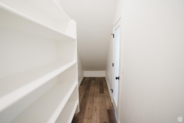 hall with dark wood-style flooring and baseboards
