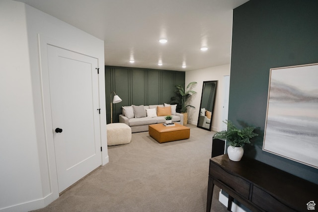 living room with recessed lighting, a decorative wall, and carpet floors