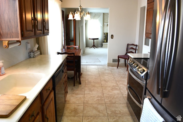 418 N 9th St, Montpelier, ID 83254 - kitchen with an inviting chandelier, light tile patterned floors, light countertops, a sink, and stainless steel appliances