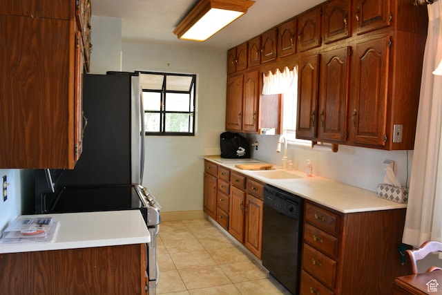 418 N 9th St, Montpelier, ID 83254 - kitchen featuring light tile patterned floors, light countertops, brown cabinetry, dishwasher, and a sink