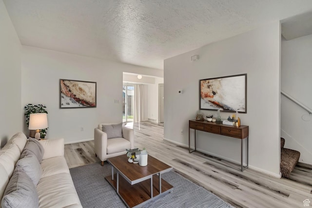 241 E Crestone Ave Unit 16A, South Salt Lake, UT 84115 - living area with light wood-type flooring, stairway, baseboards, and a textured ceiling