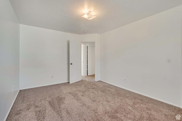 241 E Crestone Ave Unit 16A, South Salt Lake, UT 84115 - unfurnished room featuring light carpet, baseboards, and a textured ceiling