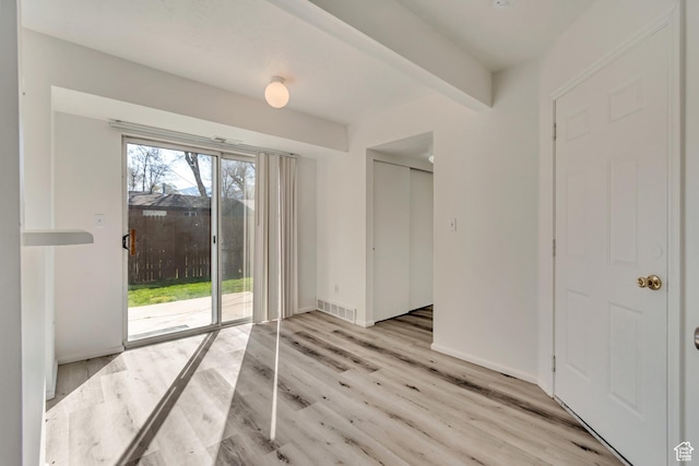 241 E Crestone Ave Unit 16A, South Salt Lake, UT 84115 - empty room with visible vents, a wealth of natural light, light wood-type flooring, and beamed ceiling