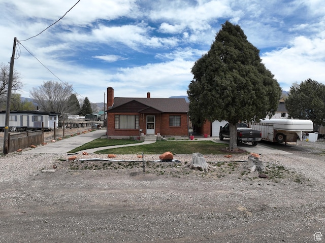 255 S Center St, Circleville, UT 84723 - view of front facade with a chimney, driveway, fence, and brick siding