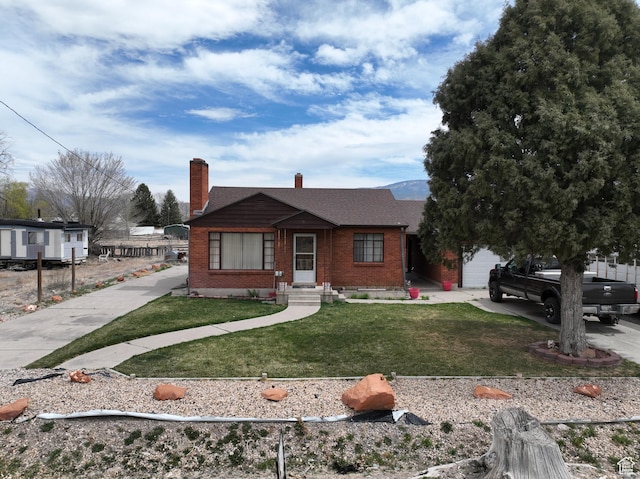 255 S Center St, Circleville, UT 84723 - view of front of property with a front yard, an attached garage, a chimney, concrete driveway, and brick siding