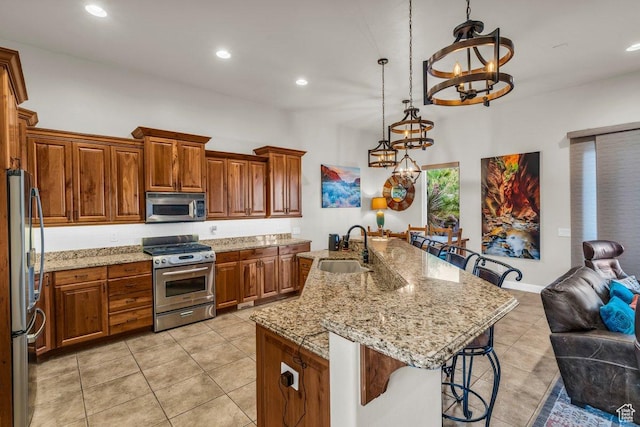 2090 N Tuweap Dr Unit 2, St George, UT 84770 - kitchen featuring brown cabinetry, a breakfast bar, a chandelier, appliances with stainless steel finishes, and a sink