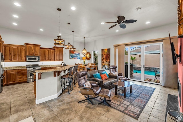 2090 N Tuweap Dr Unit 2, St George, UT 84770 - kitchen with a breakfast bar, open floor plan, brown cabinets, ceiling fan, and stainless steel appliances