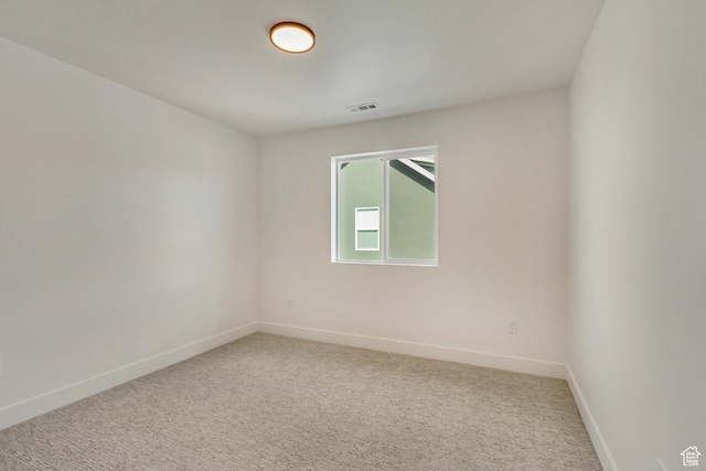 unfurnished room with visible vents, baseboards, and light colored carpet
