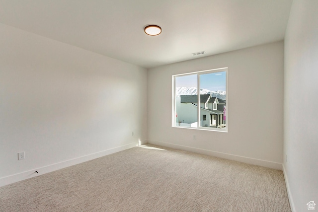 unfurnished room with visible vents, baseboards, and light carpet
