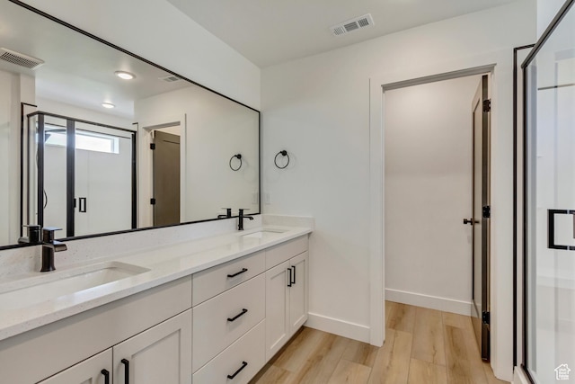 full bathroom with visible vents, a sink, and wood finished floors