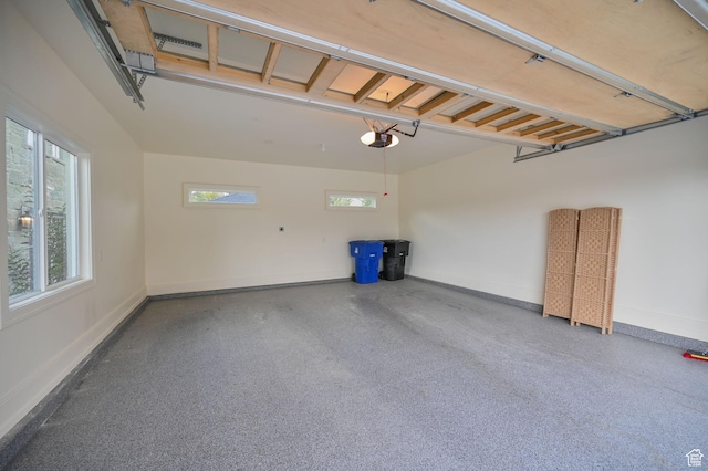 garage featuring a garage door opener and baseboards