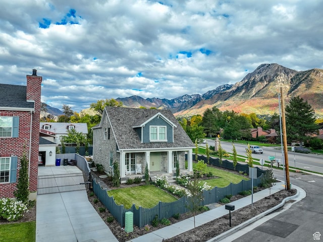 view of front of house with a mountain view, a fenced front yard, and concrete driveway