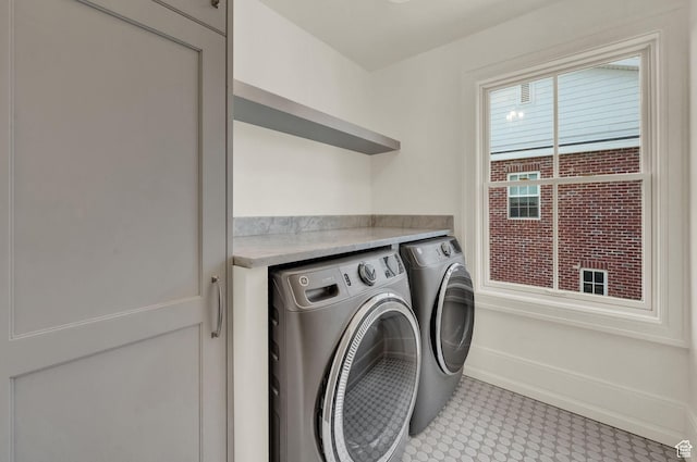 washroom with laundry area, baseboards, and washer and clothes dryer