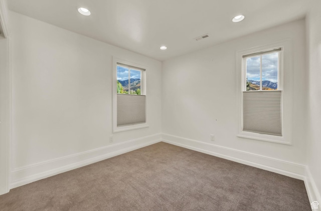 empty room with visible vents, baseboards, carpet, and recessed lighting
